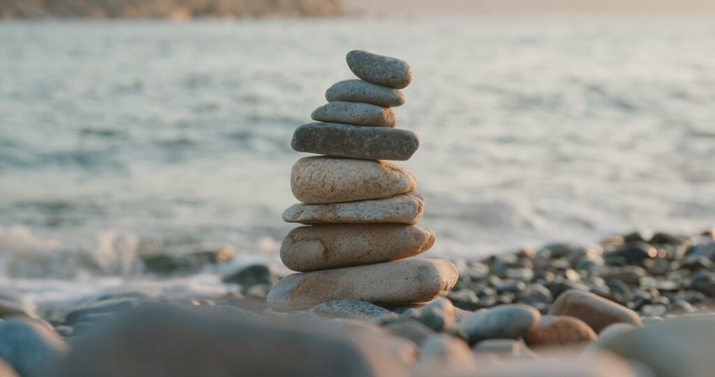 balanced pebble pyramid on the beach at sunset utc dimensioni grandi